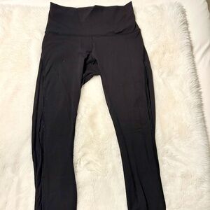 Lululemon black leggings with scalloped bottom and dotted mesh up legs